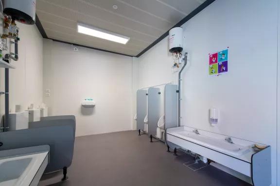 Bloc sanitaire modulaire pour enfants avec équipements adaptés, installé dans une école Algeco