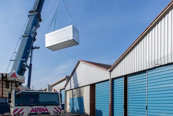 Grutage d’un module ALGECO® au-dessus des bâtiments techniques pour l’installation d’un centre d’archives à Montauban