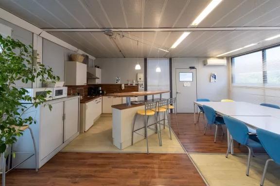 Salle de pause d’entreprise modulaire ALGECO® avec coin cuisine et table conviviale