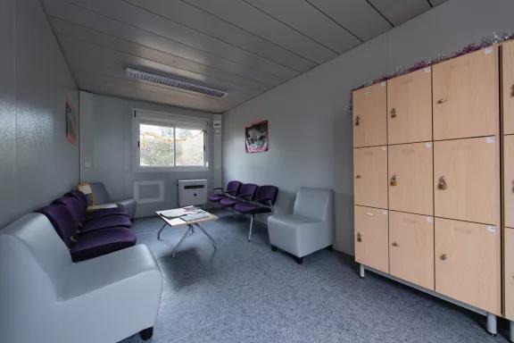 Salle de pause d’entreprise modulaire ALGECO® avec fauteuils violets et casiers en bois clair