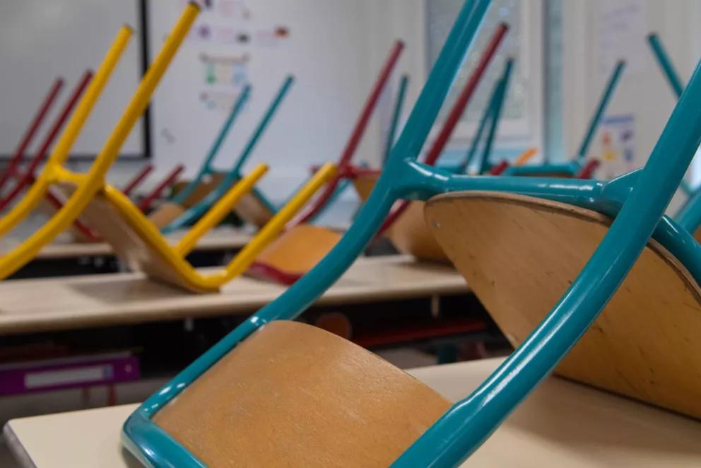 Salle de classe modulaire ALGECO® avec chaises retournées sur les bureaux