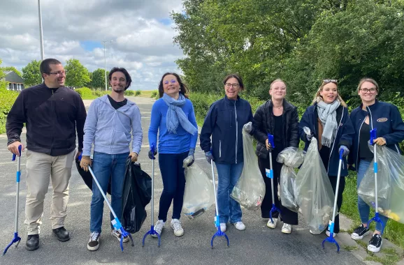 groupe de personnes sur une route participant à une activité de nettoyage en plein air