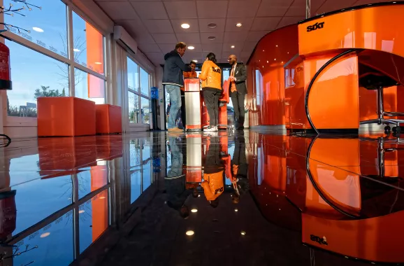 intérieur d'un bureau de location de voitures moderne, sol lisse réfléchissant, grandes fenêtres et mobilier orange vif
