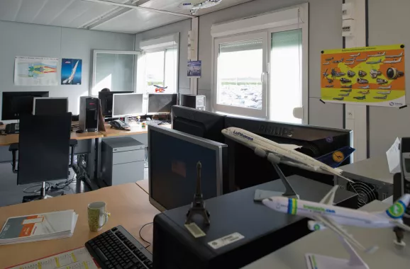 bureau modulaire aéronautique ALGECO® avec ordinateurs et maquettes d’avion