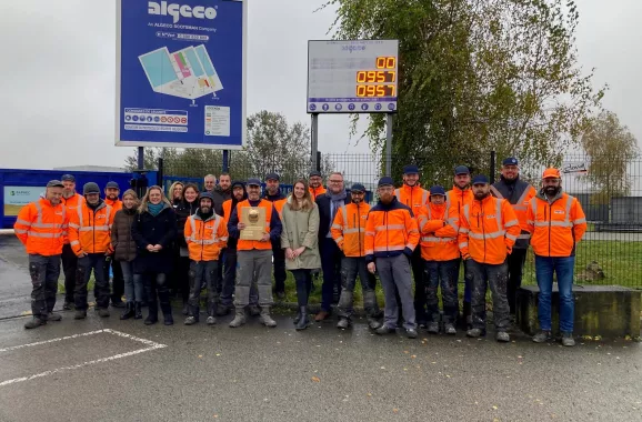Équipe en tenue de sécurité avec un casque d’or devant un site Algeco