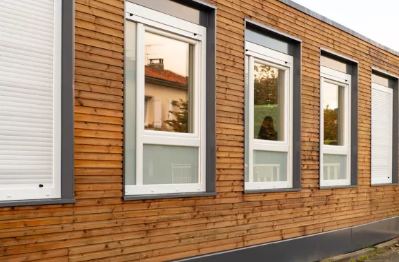 açade d’une école modulaire ALGECO® avec bardage en bois et larges fenêtres