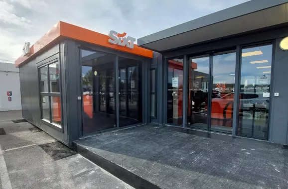Bâtiment modulaire ALGECO® utilisé comme agence de location de voitures Sixt avec façade vitrée