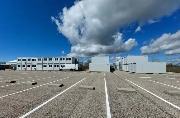 Ensemble de bâtiments modulaires ALGECO® installés sur un parking avec ciel dégagé et nuages