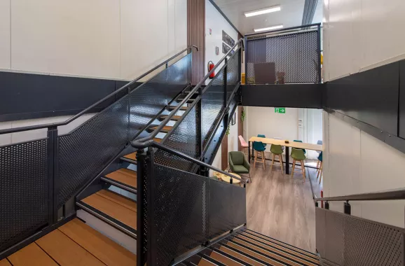 Escalier intérieur en bois de la cafétéria modulaire ALGECO® temporaire de L-Acoustics reliant les deux niveaux
