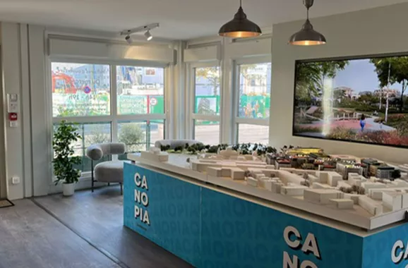 Intérieur de la Maison du projet Canopia composée de modules ALGECO® avec maquette d’exposition