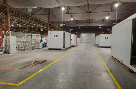 Ligne de production de bâtiments modulaires ALGECO® alignés dans un atelier industriel