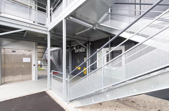 Ascenseur PMR et escalier extérieur du lycée modulaire ALGECO® Pierre de Coubertin à Meaux