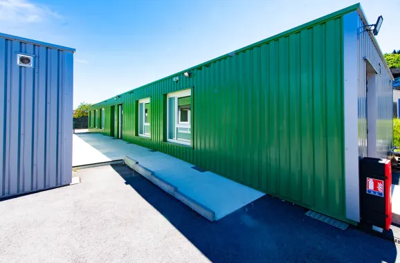 Façade latérale verte des salles de classe modulaires ALGECO® ENILEA à Mamirolle