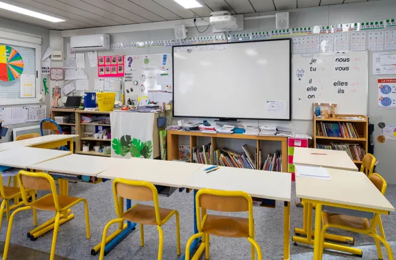 Salle de classe modulaire ALGECO® avec tableau blanc interactif, tables et supports pédagogiques
