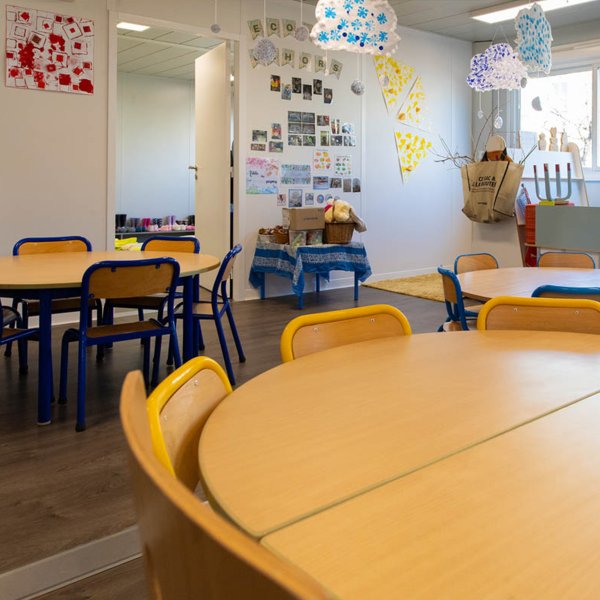 Tables rondes et décoration colorée dans une salle de maternelle modulaire ALGECO®