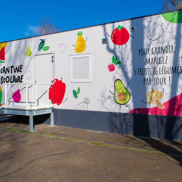 Façade colorée d’une cantine scolaire modulaire ALGECO® décorée de fruits à Chalon-sur-Saône