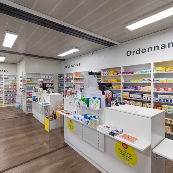 Intérieur d’une pharmacie modulaire ALGECO® temporaire à Bordeaux avec comptoirs et rayonnages de médicaments