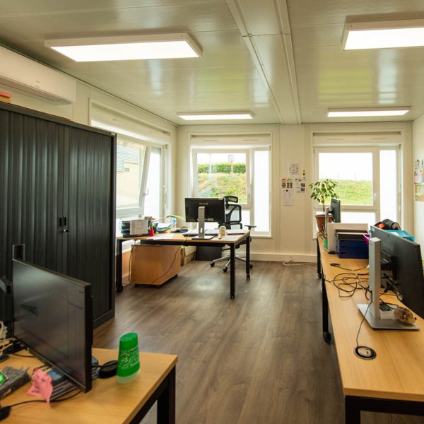  Intérieur lumineux de bureaux modulaires ALGECO® équipés de postes de travail et rangements