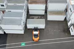 Vue aérienne de blocs modulaires ALGECO® rangés par un chariot élévateur en plein air