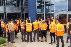 groupe d’intervenants d’Algeco en tenue de sécurité devant un bâtiment industriel ou commercial