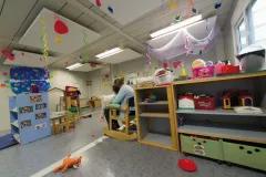 Adulte lisant un livre pour un enfant dans une crèche modulaire ALGECO®