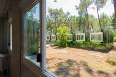 vue depuis une fenêtre du complexe de logements modulaires ALGECO® temporaire avec façade en trompe l’œil dans une forêt d’Arès (Bassin d’Arcachon)