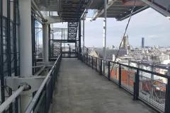 Passerelle extérieure sur chantier en hauteur avec vue panoramique sur les toits de Paris par Altempo
