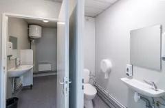 Bloc sanitaire de chantier équipé de WC, lavabos, miroir et distributeurs muraux